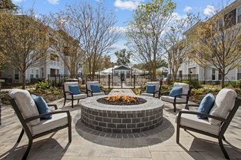an outdoor patio with chairs and a fire pit